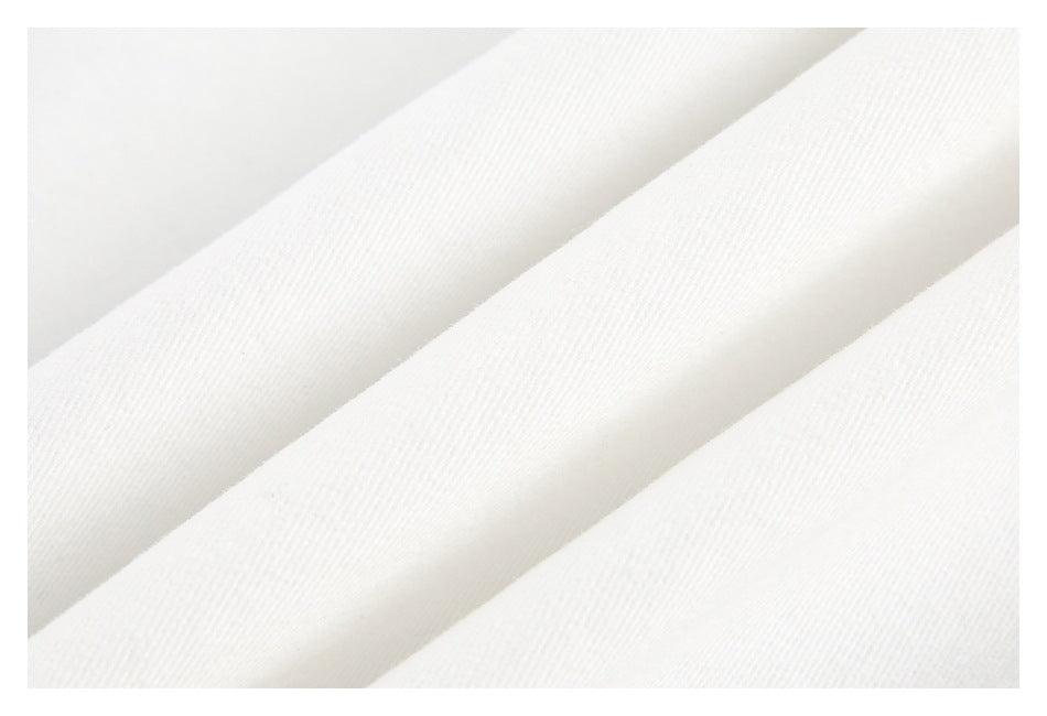 Close-up of white fabric folded into soft ridges, showing a fine, uniform texture.