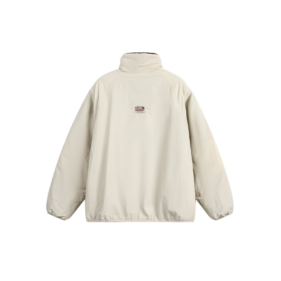 Back view of an ivory jacket with a high collar, raglan sleeves, and a small embroidered logo.