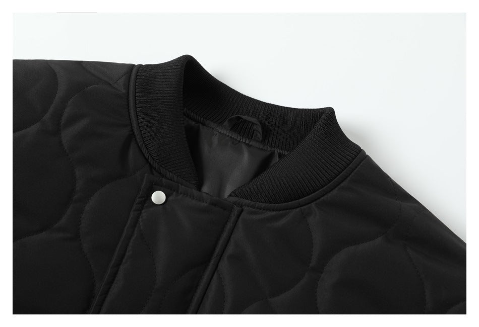Close-up of the black jacket’s ribbed collar, quilted fabric and silver snap closure.