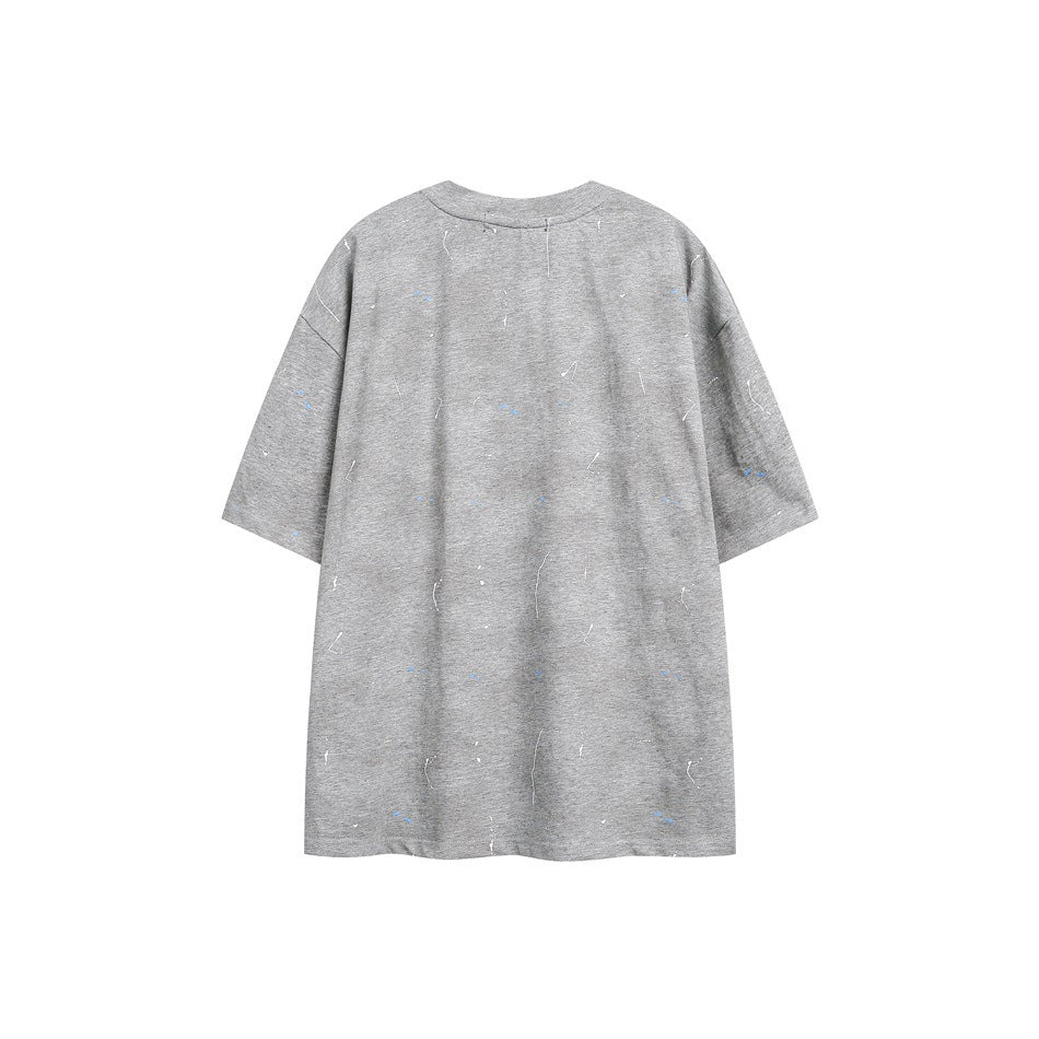 Back of an isolated oversized gray short-sleeve T-shirt with scattered small blue and white marks.
