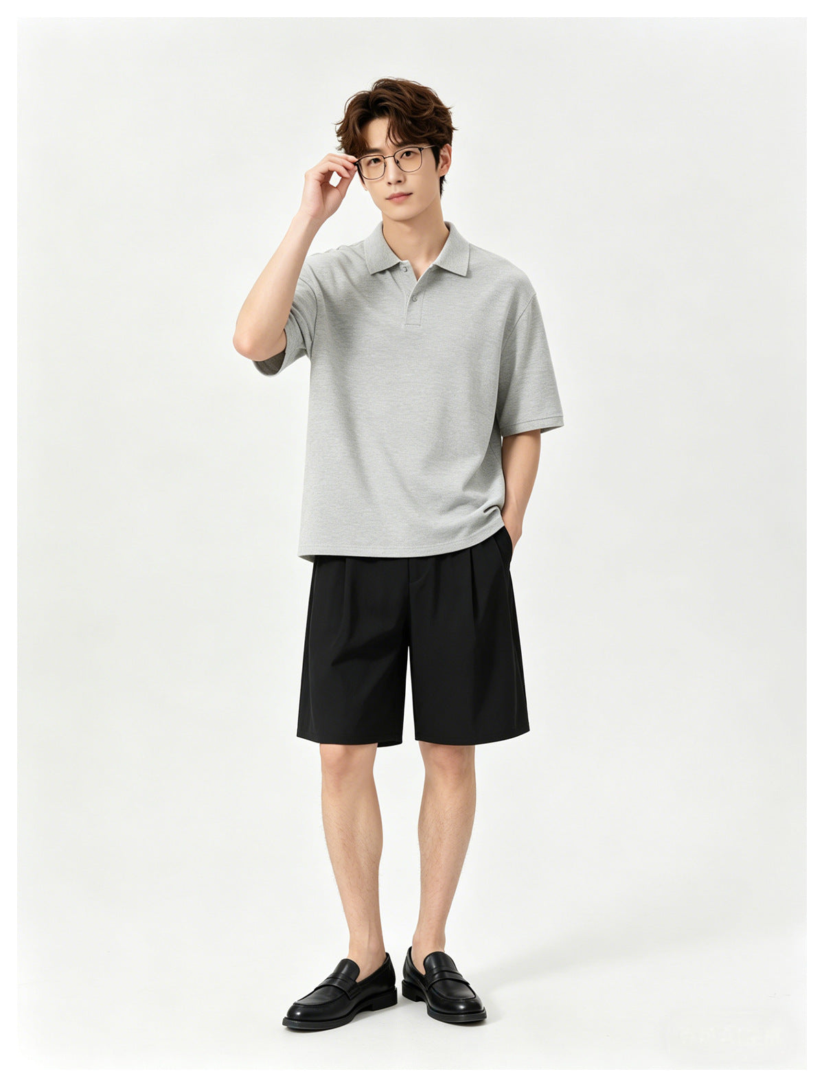 Model wearing a light gray short-sleeve polo, black shorts and black loafers.