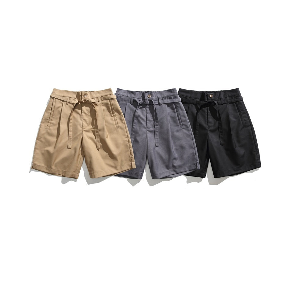 Three pairs of pleated shorts with tie belts in tan, gray, and black, shown from the front.