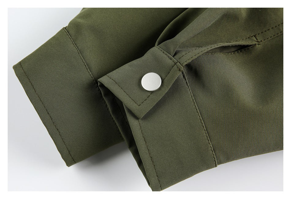 Close-up of an olive sleeve cuff with a silver snap fastening and stitched tab.