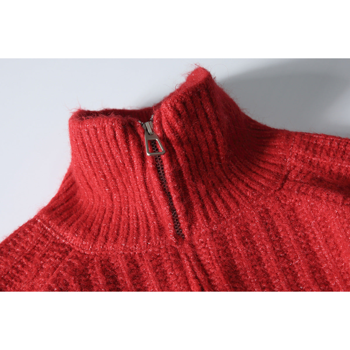Close-up of a red rib-knit sweater's high collar and short front zipper.