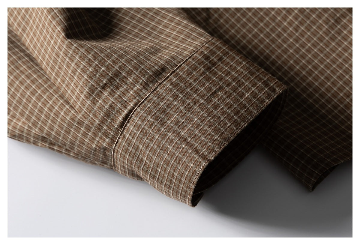 Close-up of the brown checked shirt's sleeve cuff and stitching.