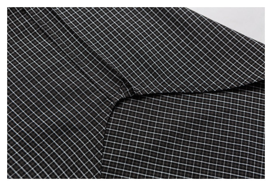 Close-up of black-and-white grid fabric folded over another matching panel, showing the seam and pattern.