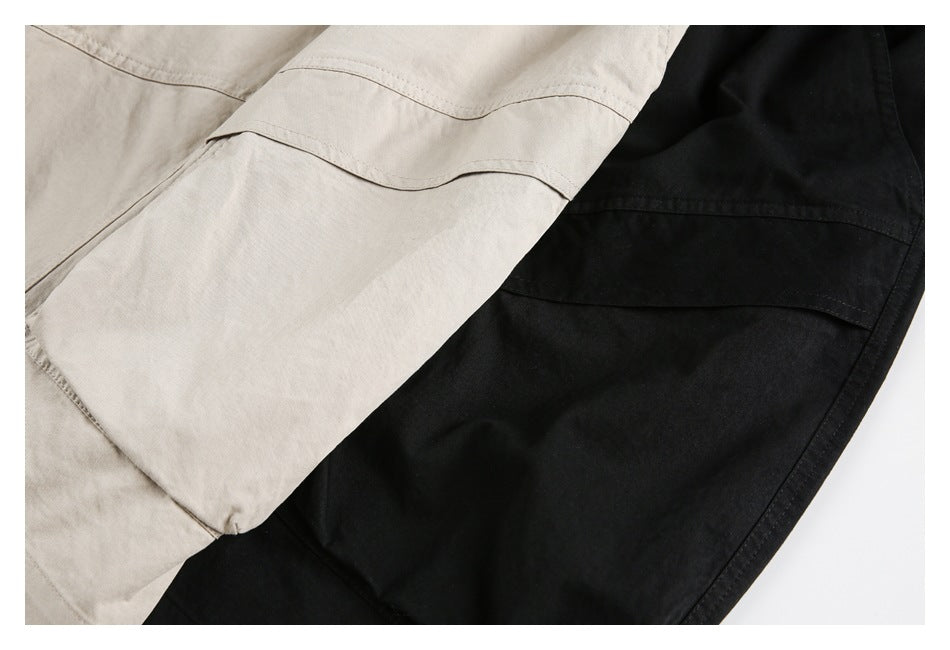 Close-up of beige and black garments overlapping, showing curved panel seams and stitching.