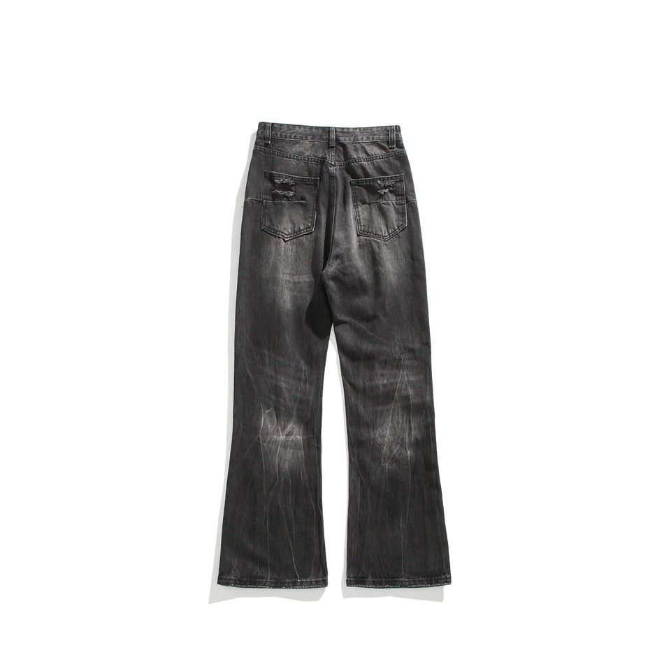 Back view of washed black flared jeans with distressed back pockets and faded streaks