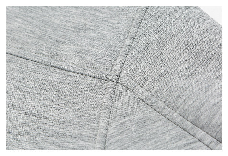 Close-up of intersecting stitched seams on a light gray heathered garment.