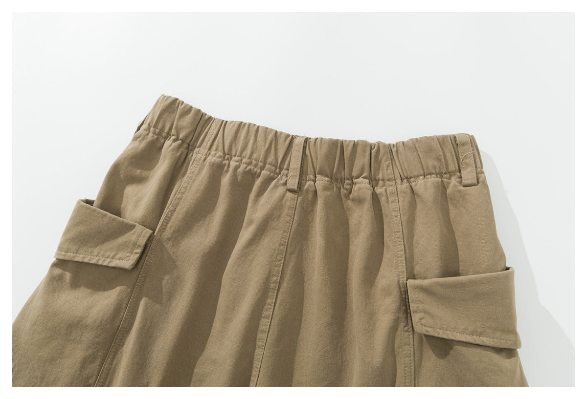 Upper back view of khaki cargo pants with an elastic waistband, belt loops and flap pockets.