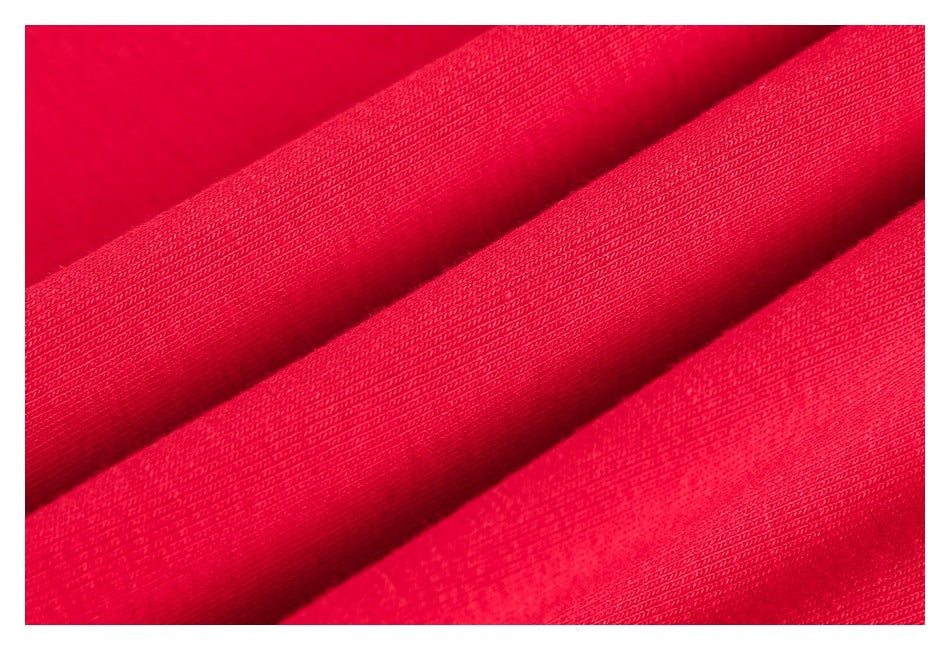 Macro view of the textured red garment fabric arranged in soft folds.
