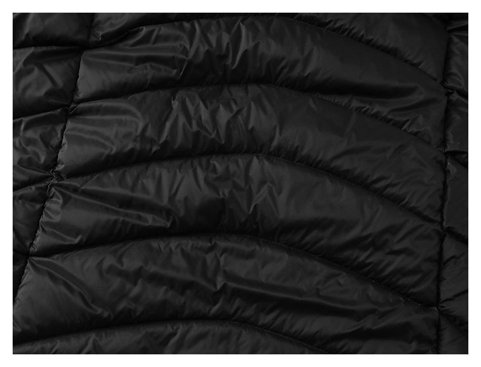 Close-up of black quilted puffer garment with curved padded channels.