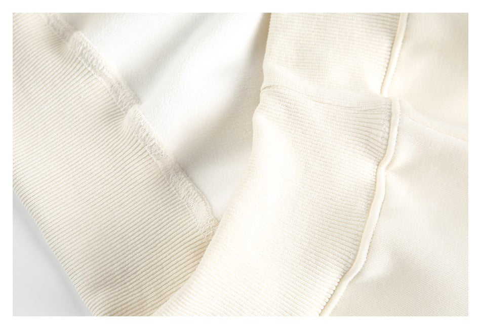 Close-up of ivory ribbed garment trim, seams, and interior stitching.