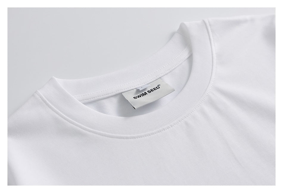 Close-up of a white T-shirt's ribbed crew neck and inner SWIM SEED label.