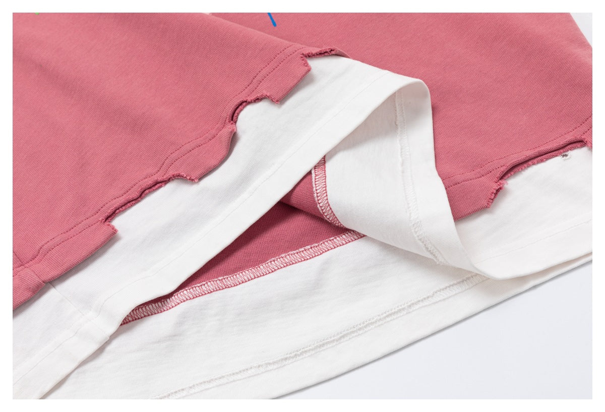 Close-up of a dusty pink garment layered over white fabric, showing the hem and stitching.