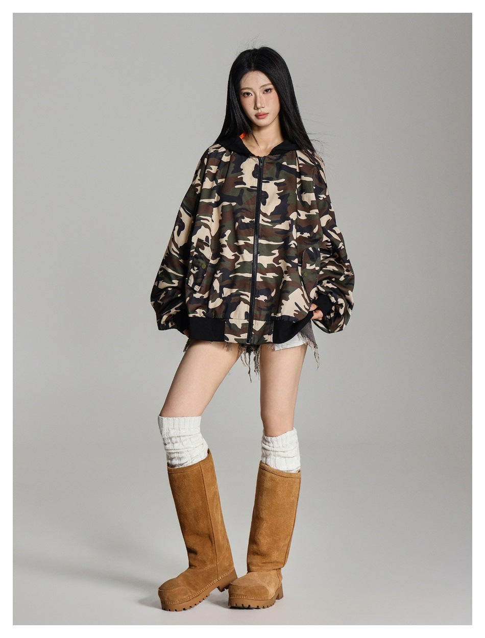 Model wearing a zipped camouflage jacket with a black hood and trim, shown from the front.