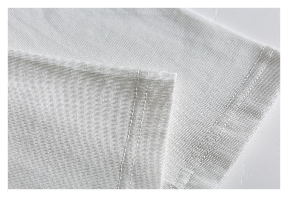 Close-up of a white garment seam with parallel stitching along a folded edge.