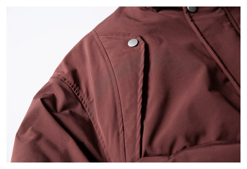 Close-up of a burgundy jacket shoulder with a stitched panel and silver snap button.