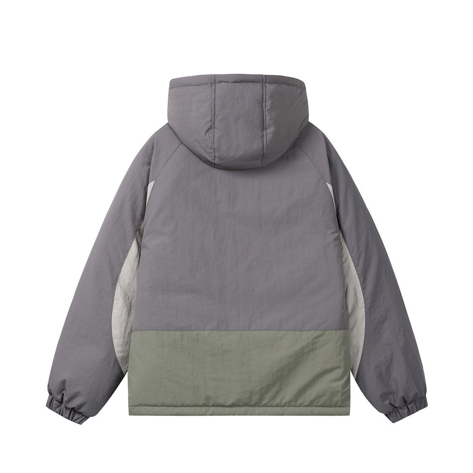 Back view of dark gray hooded jacket with sage green lower panel and off-white side panels, flat lay