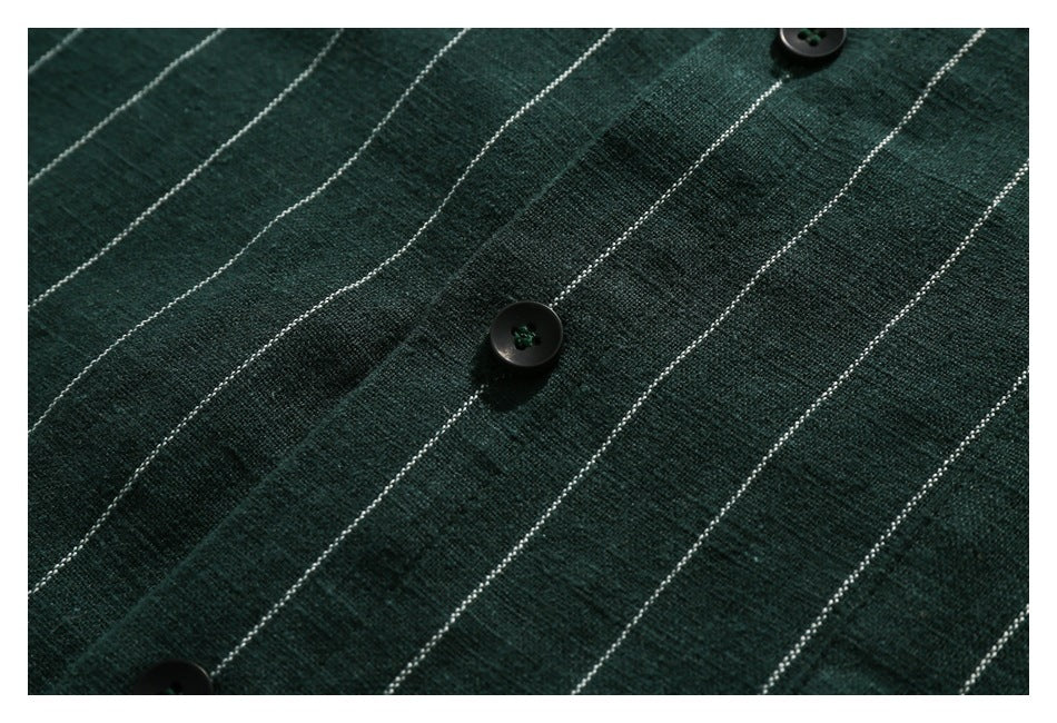 Close-up of dark green, white-striped fabric with several black buttons.