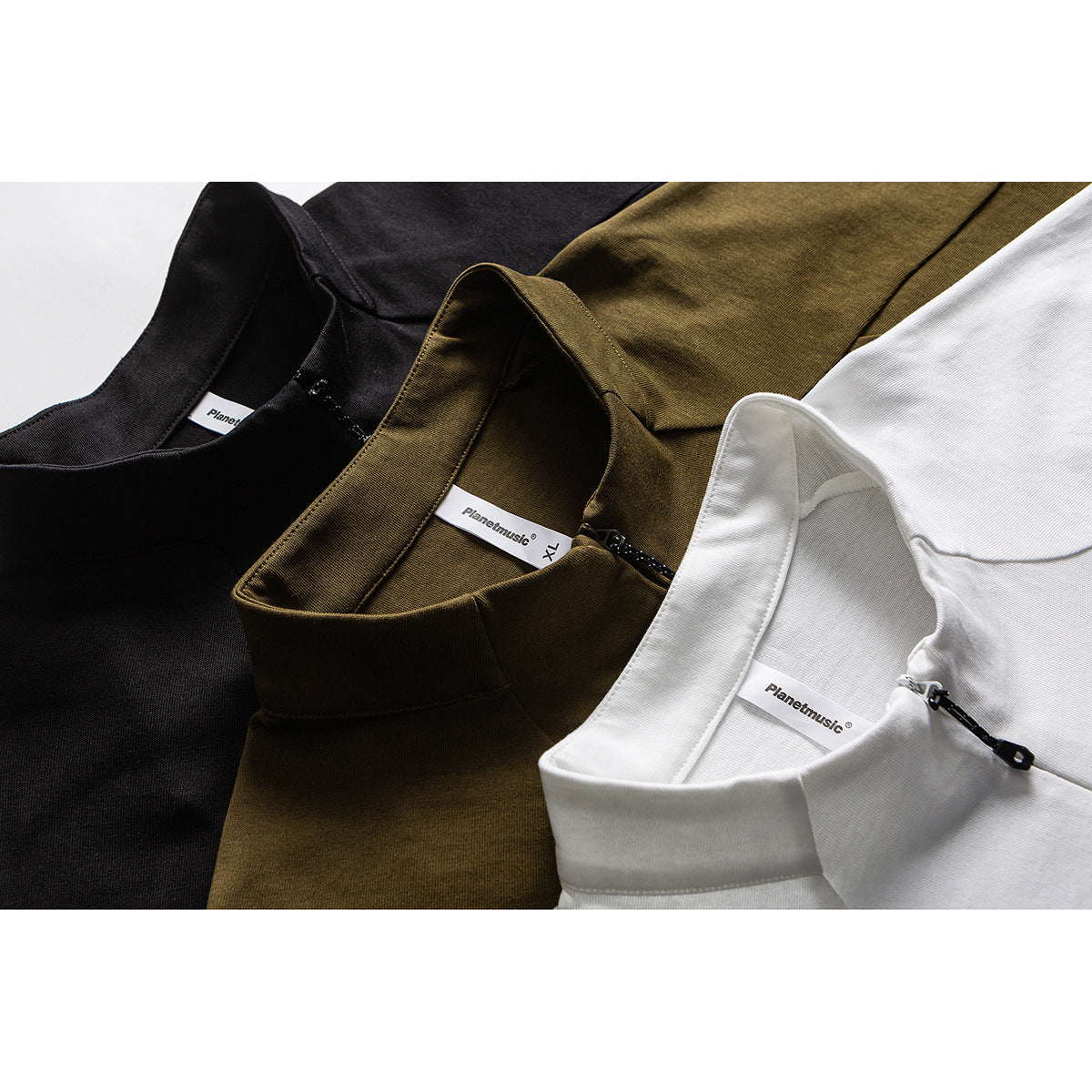 Close-up of black, olive, and white tops showing stand collars, short zippers, and neck labels.