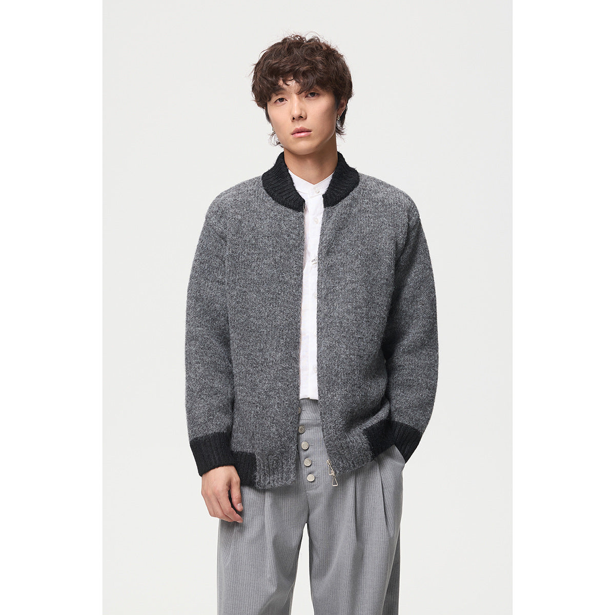Front view of a model wearing an open dark gray knit jacket with black ribbed trim and a stand collar.