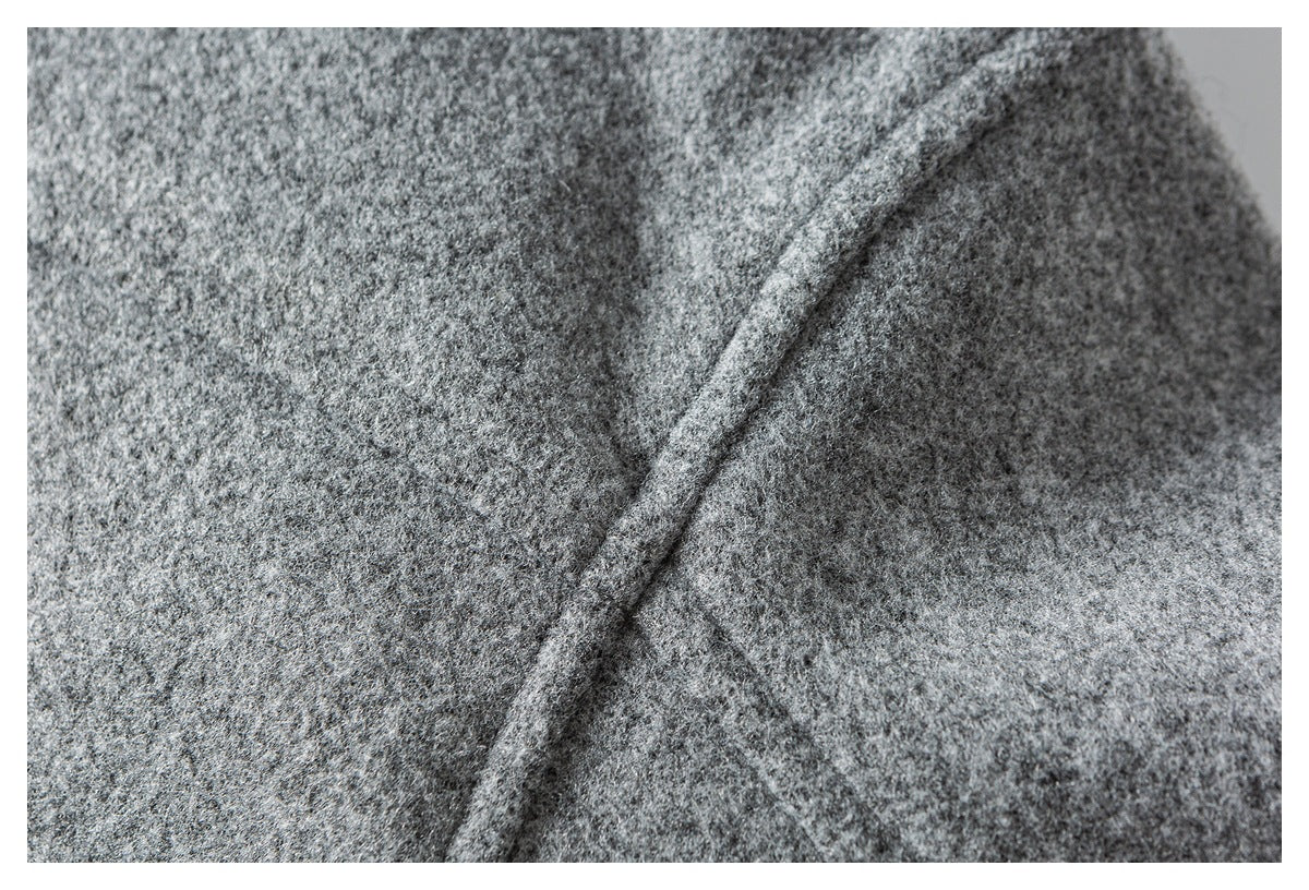 Close-up of mottled gray garment fabric with a raised diagonal seam.