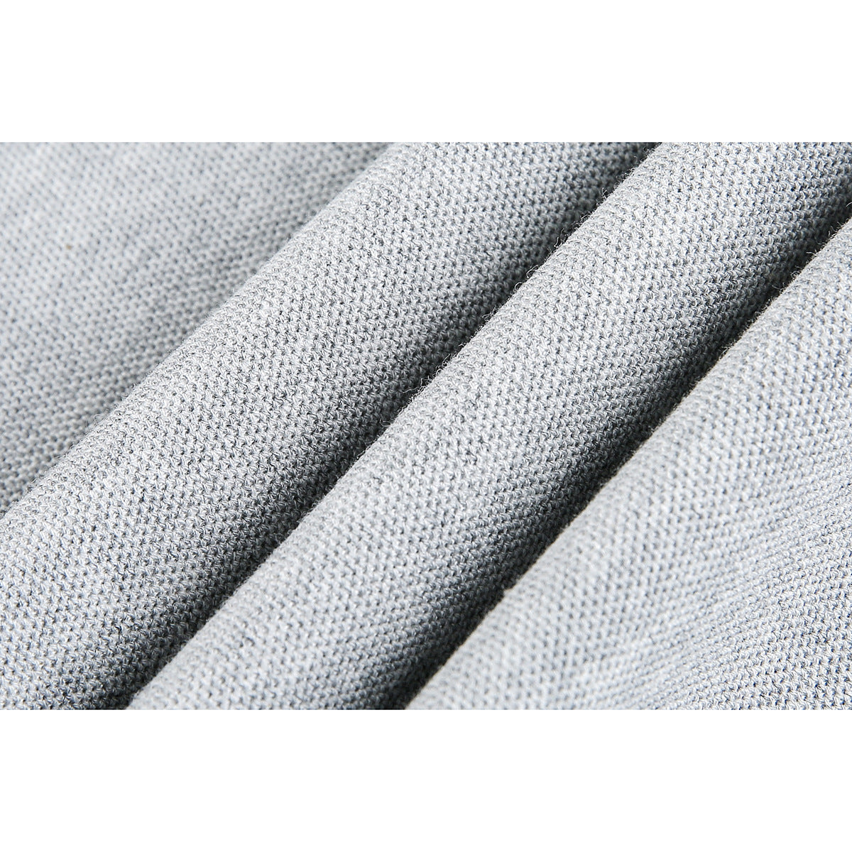 Macro view of light gray knit polo fabric arranged in soft folds.