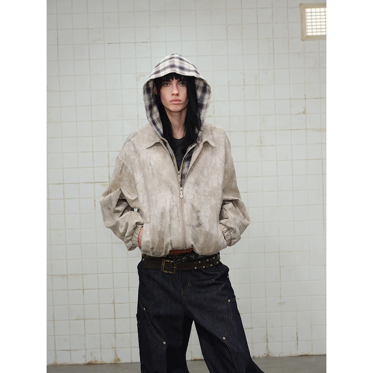 Model wearing a beige mottled zip-up jacket with a plaid hood, shown from the front.