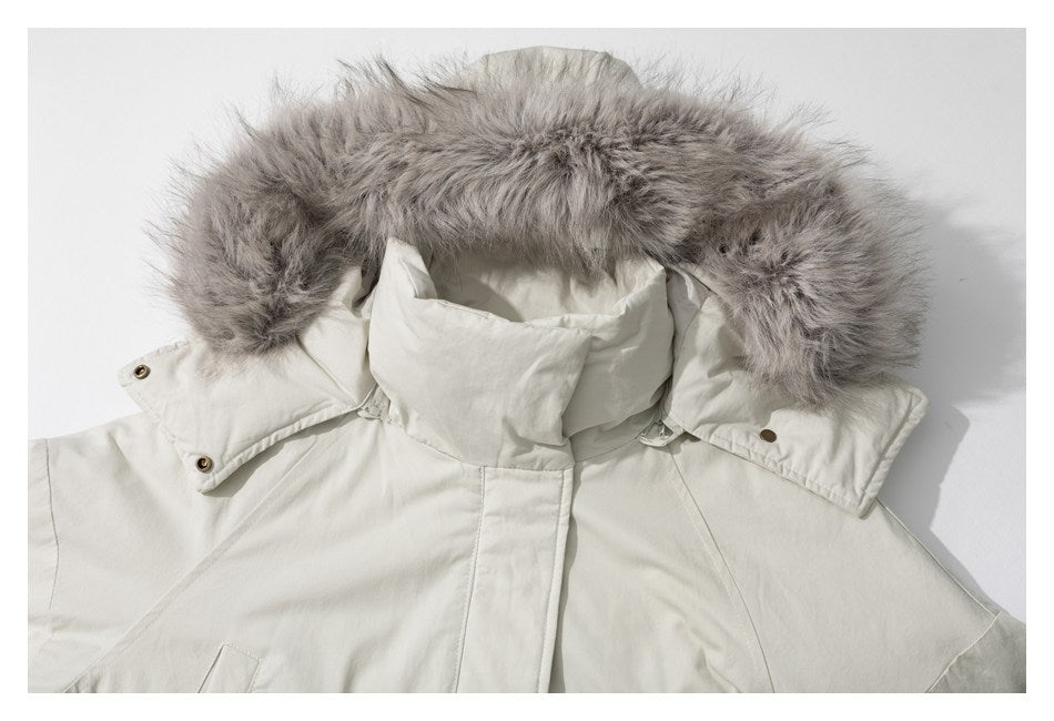 Close-up of an ivory coat’s hood, high collar, and gray fur trim against a light background.