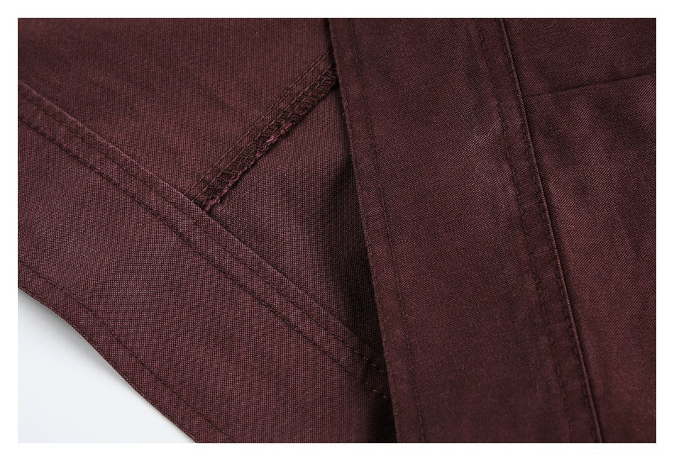 Close-up of burgundy garment construction, showing overlapping fabric panels and finished seams.