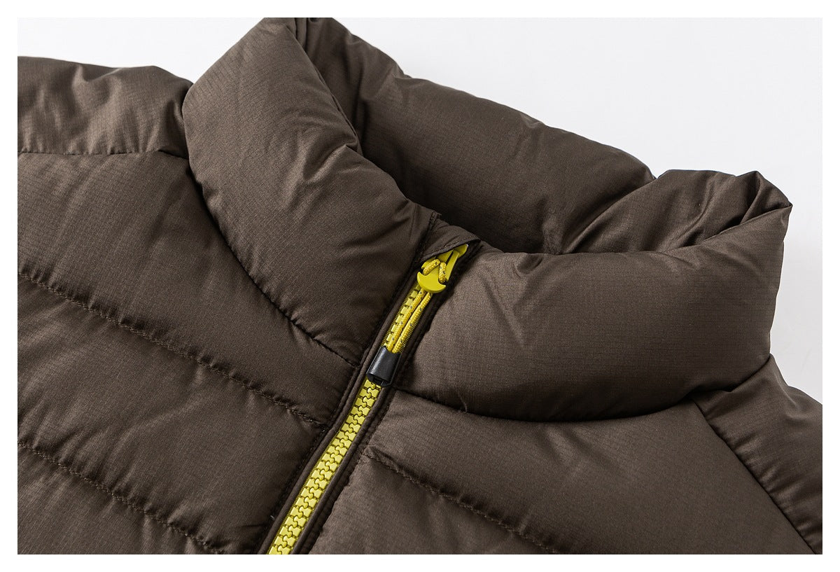 Close-up of a brown quilted jacket collar and bright yellow front zipper.