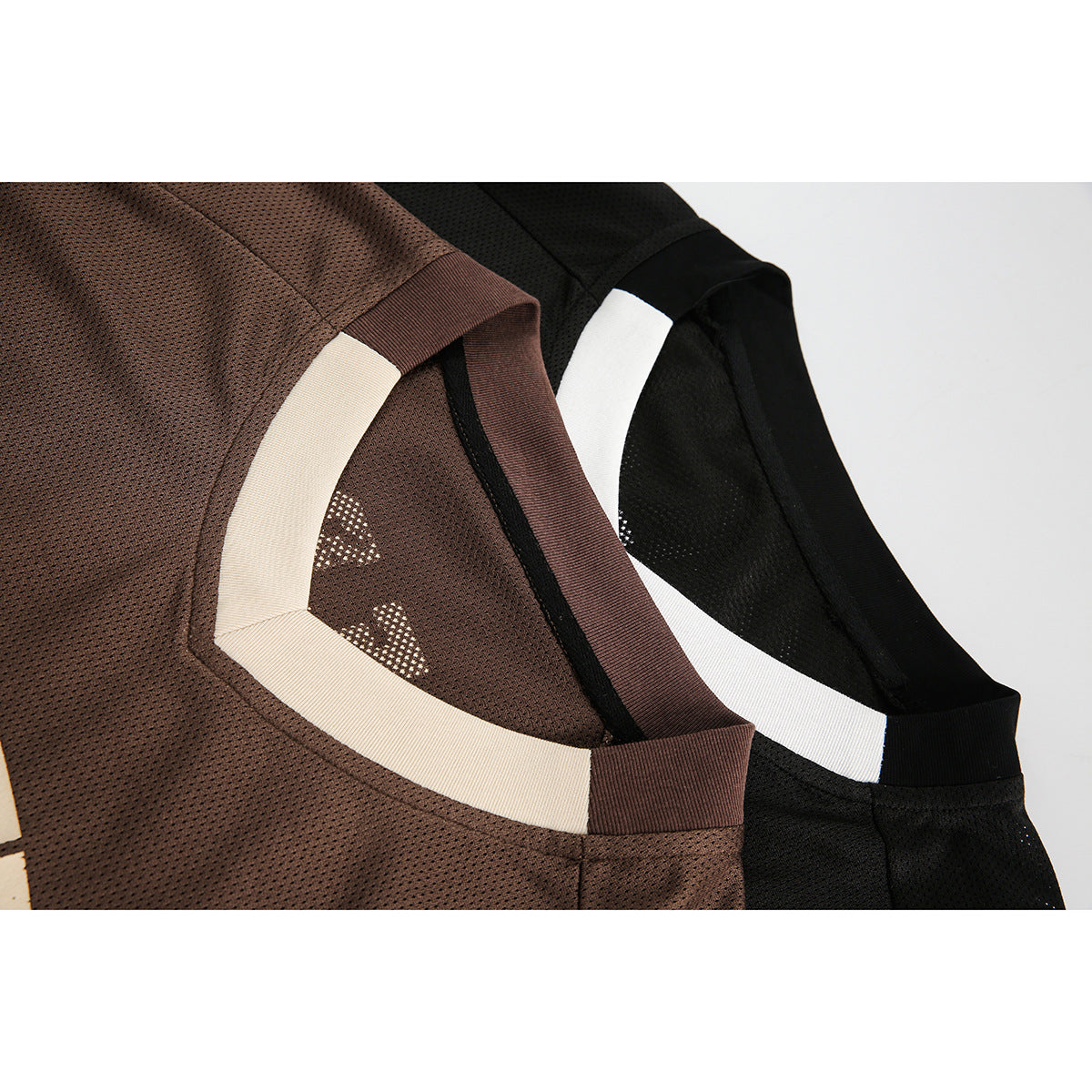Close-up of brown and black mesh V-neck shirts showing cream and white collar trim.