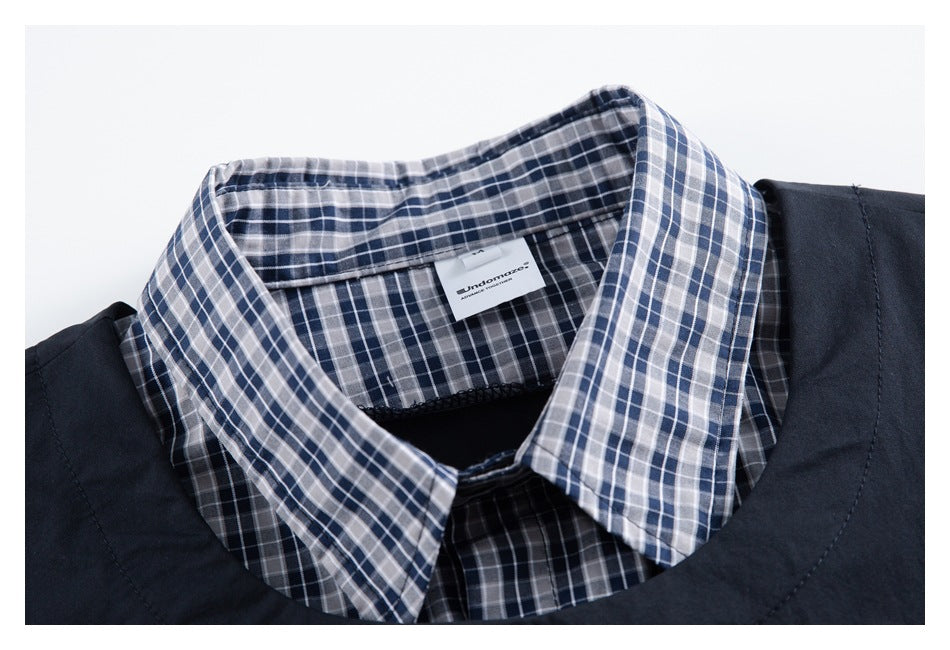 Close-up of a navy, gray, and white plaid shirt collar and sewn-in label.