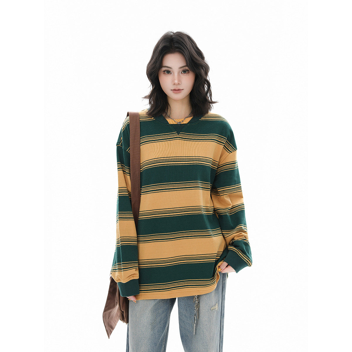Model in a green and mustard striped oversized long-sleeve shirt, shown from the front with jeans.