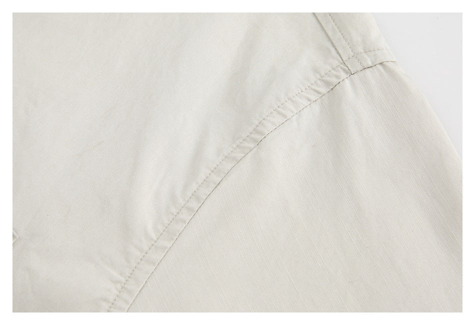Close-up of the curved shoulder seam on an off-white shirt.