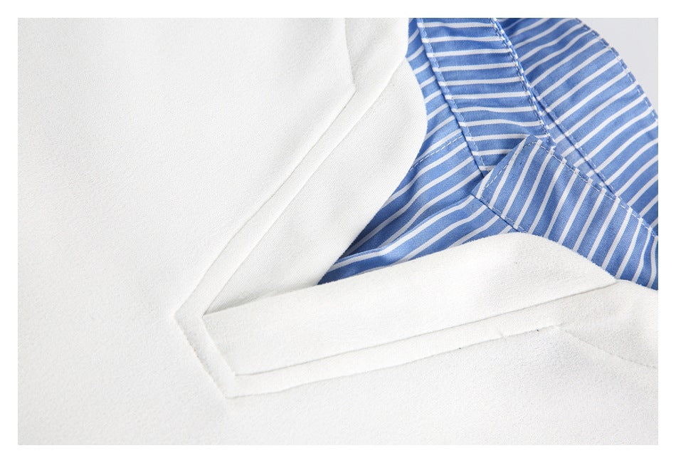 Close-up of white V-neck edging beside blue-and-white striped collar fabric.
