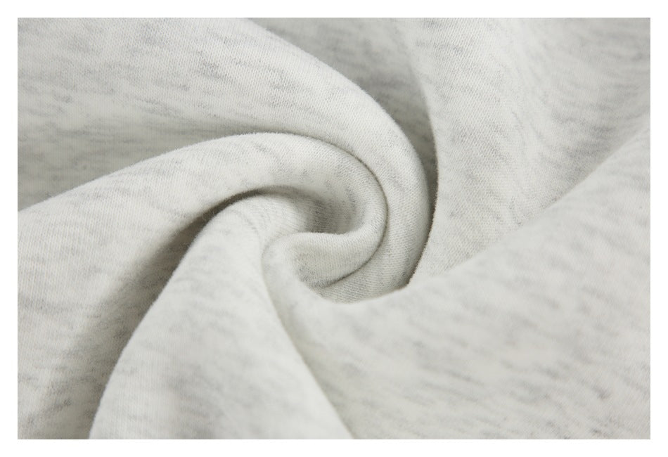 Close-up of light gray heather sweatshirt fabric gathered into a spiral fold.