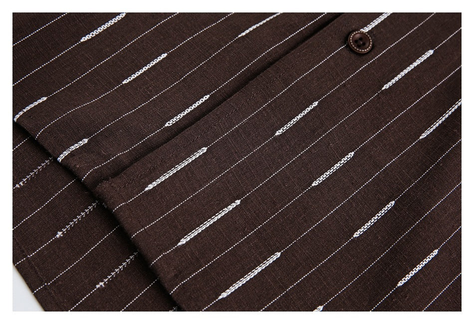 Close-up of a brown button and overlapping fabric panels with thin white dashed stripes.