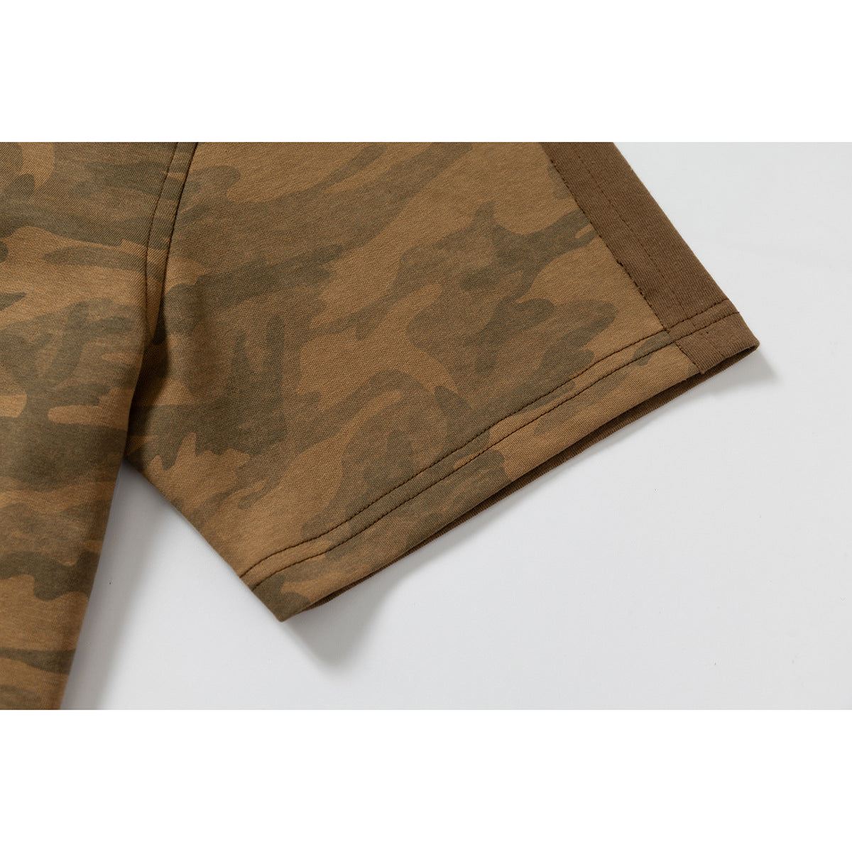 Close-up of the double-stitched hem on a brown camouflage T-shirt sleeve.