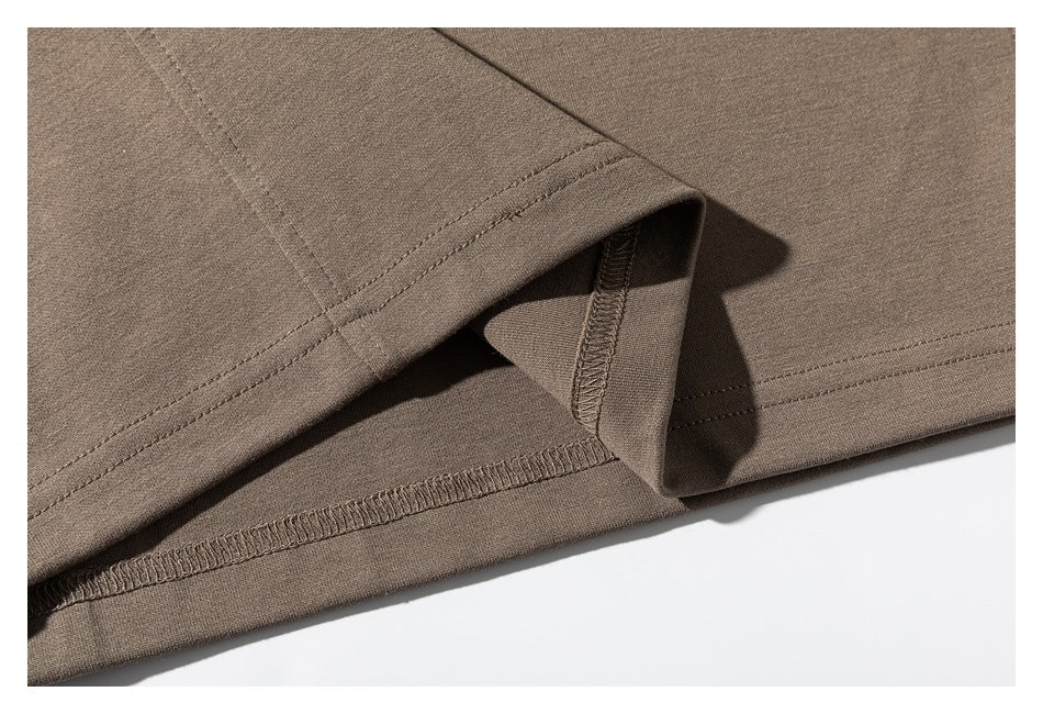 Close-up of the taupe sweatshirt's sleeve cuff and hem, showing stitching and overlock seams.