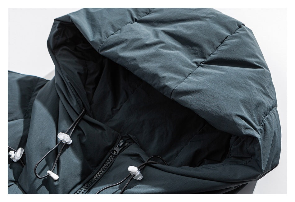 Close-up of a dark blue-gray padded jacket hood with black drawcords and white toggles.