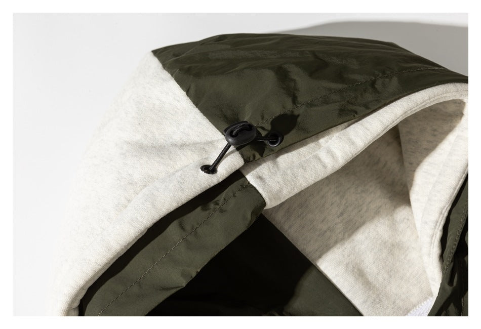 Close-up of the hoodie’s two-tone hood with an olive panel and black drawcord toggle.
