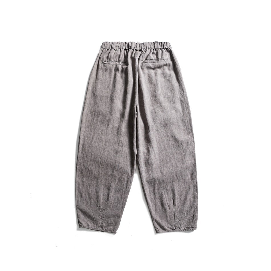 Back view of light gray relaxed trousers with an elastic waistband and two rear pockets.