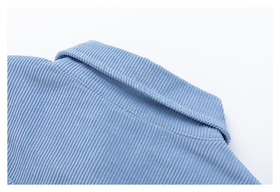 Close-up of the folded collar and stitching on a light blue corduroy jacket.