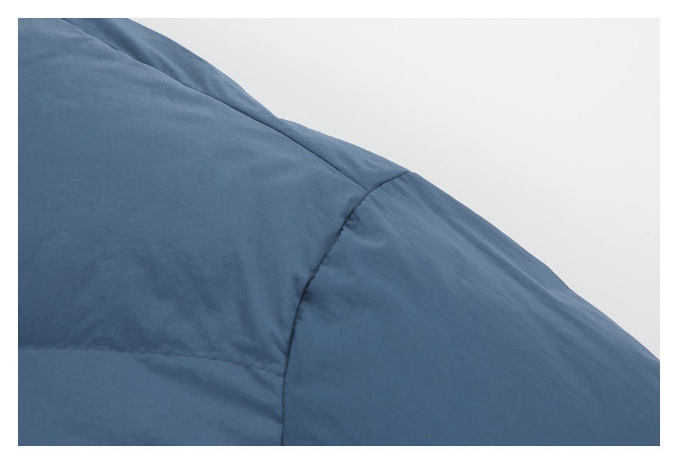 Close-up of the slate-blue jacket's padded shoulder seam and stitched panels.