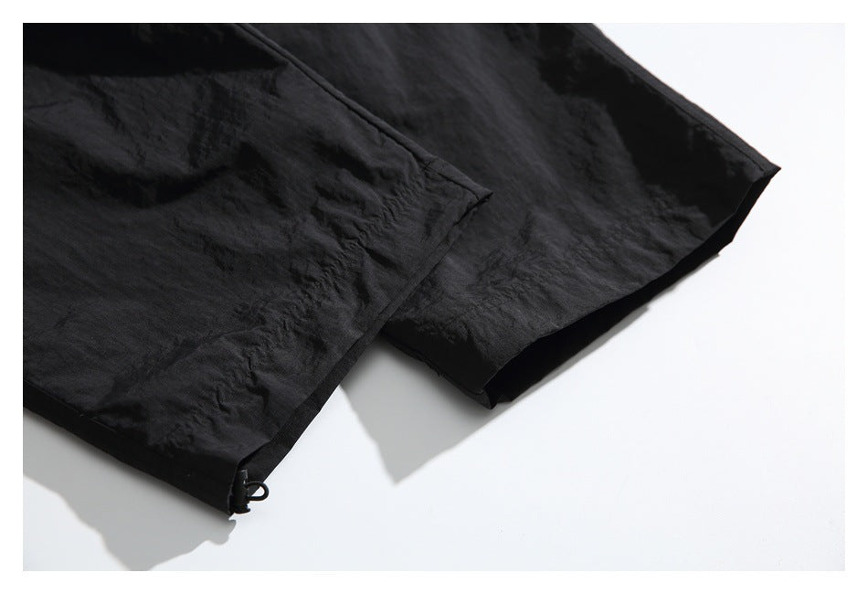 Close-up of the lower legs and hem details of black pants.