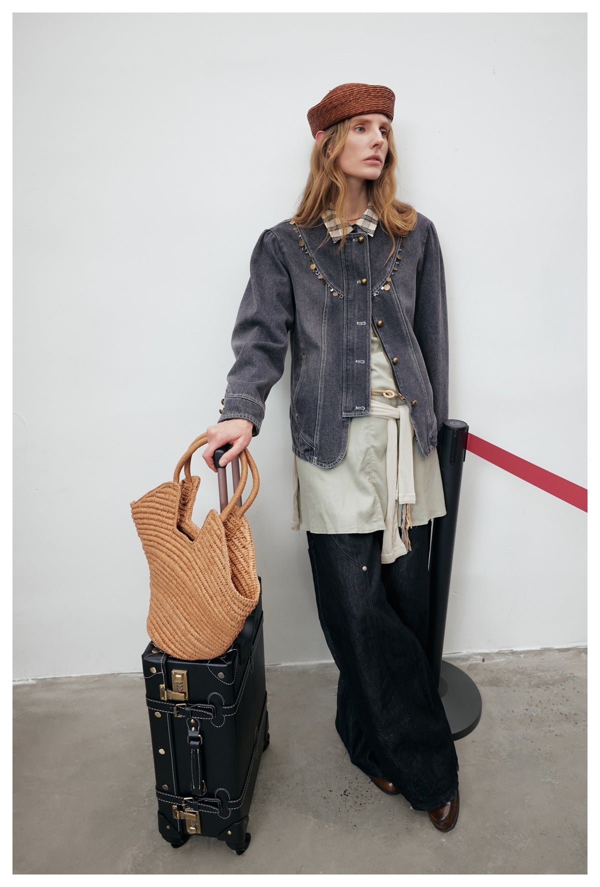 Full-length model wearing a charcoal embellished denim jacket, pale tunic, and wide-leg black trousers.