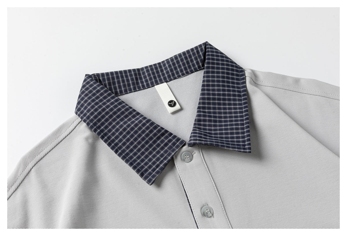 Close-up of the gray polo's navy checked collar, button placket, and small interior size tag.