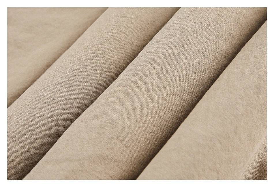 Close-up of beige garment fabric arranged in soft folds, showing its surface and drape.